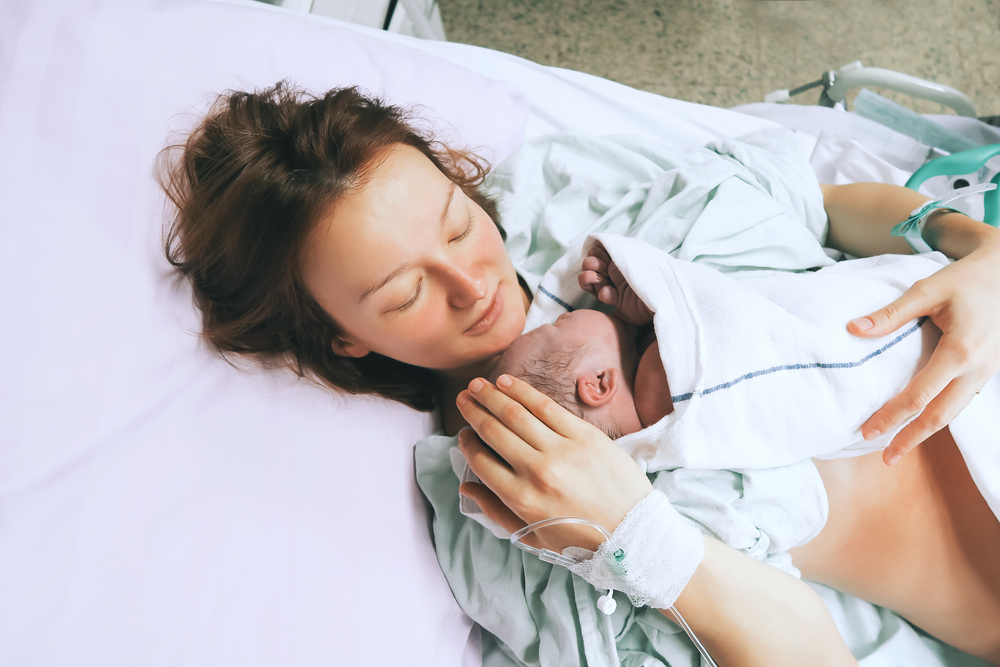 A new parent holding their new born baby