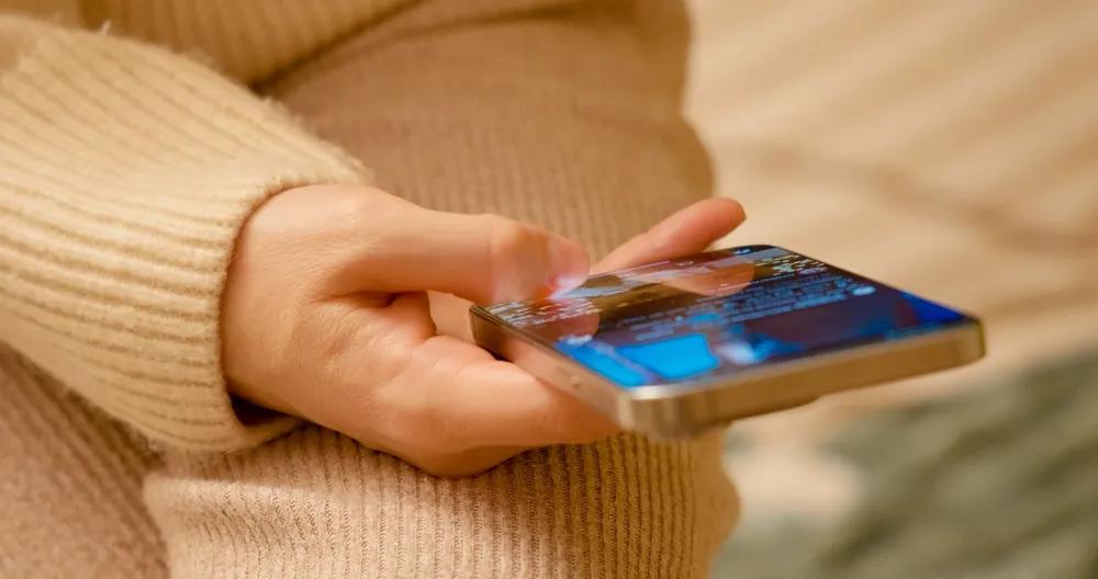 A person holding their phone and scrolling online