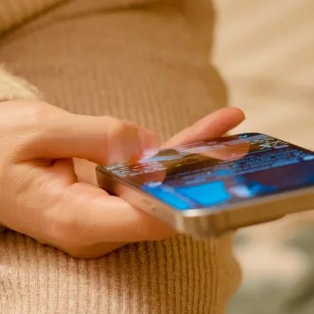 A person holding their phone and scrolling online